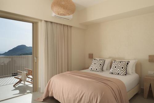 a bedroom with a bed and a balcony at Stella in the Village Studios in Plakias