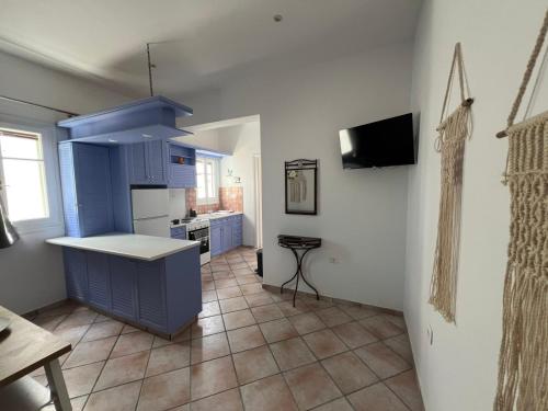 a kitchen with blue cabinets and a tile floor at Eclipse Tales in Adamas