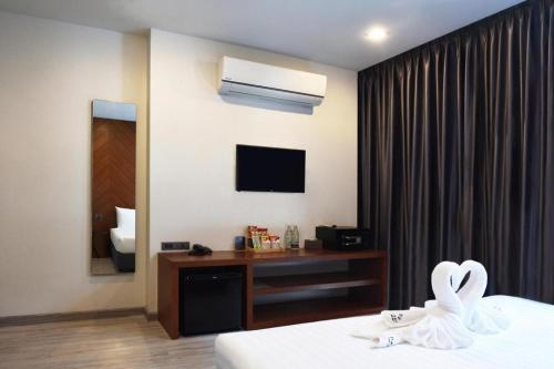 a hotel room with a bed and a television at INBED in Sadao