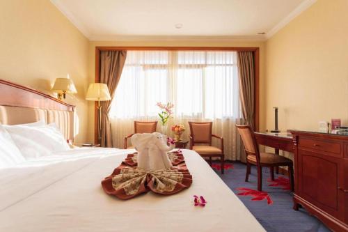a hotel room with a bed and a desk at Quanzhou Hotel in Quanzhou