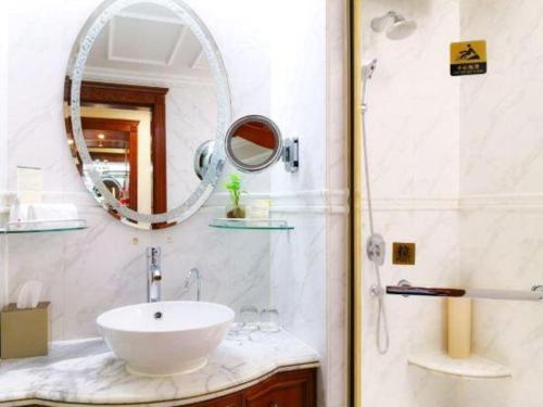 a bathroom with a sink and a mirror at Quanzhou Hotel in Quanzhou