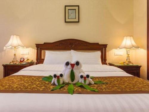 two stuffed birds sitting on top of a bed at Quanzhou Hotel in Quanzhou