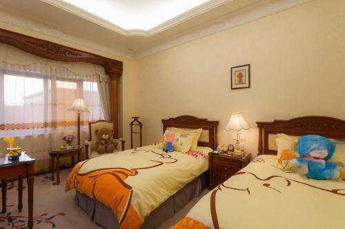 a bedroom with two beds with stuffed animals on them at Quanzhou Hotel in Quanzhou