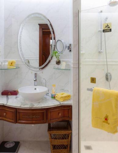 a bathroom with a sink and a shower with a mirror at Quanzhou Hotel in Quanzhou