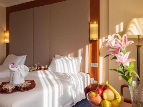 a bedroom with a bed with a bowl of fruit on it at Quanzhou Hotel in Quanzhou