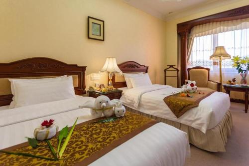 a hotel room with two beds with stuffed animals on them at Quanzhou Hotel in Quanzhou