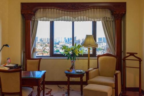 a living room with a chair and a table and a window at Quanzhou Hotel in Quanzhou