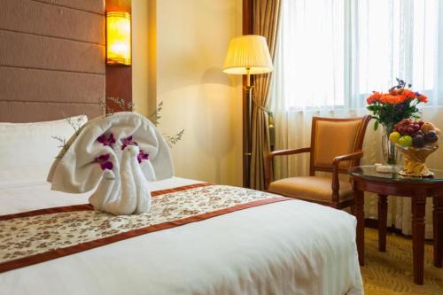 a hotel room with a bed with a flower decoration on it at Quanzhou Hotel in Quanzhou