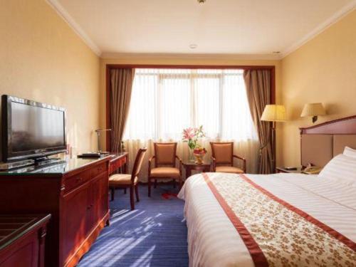 a hotel room with a bed and a television at Quanzhou Hotel in Quanzhou