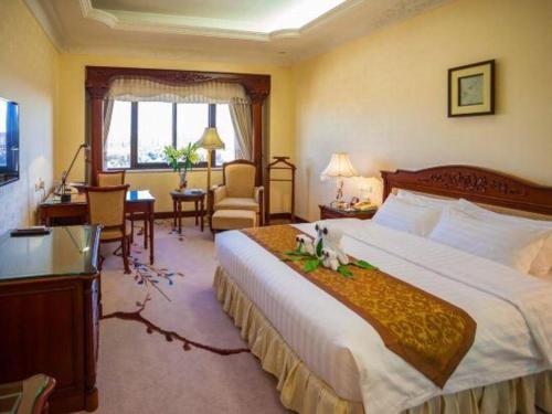 a hotel room with a large bed and a desk at Quanzhou Hotel in Quanzhou