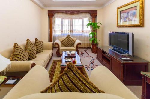 a living room with couches and a flat screen tv at Quanzhou Hotel in Quanzhou