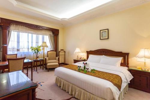 a hotel room with a large bed and a desk at Quanzhou Hotel in Quanzhou