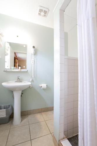 a white bathroom with a sink and a mirror at Relax Inn By OYO Natural Bridge I-81 in Natural Bridge