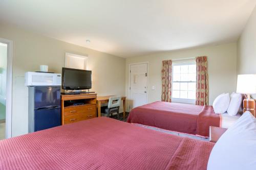 a hotel room with two beds and a flat screen tv at Relax Inn By OYO Natural Bridge I-81 in Natural Bridge