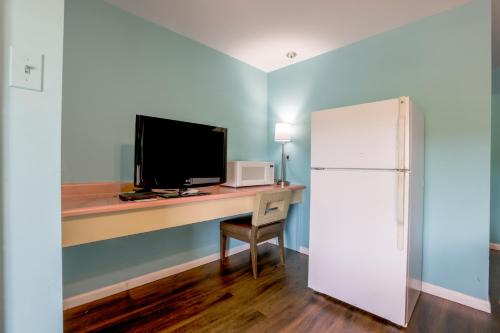 a room with a desk with a television and a refrigerator at Relax Inn By OYO Natural Bridge I-81 in Natural Bridge