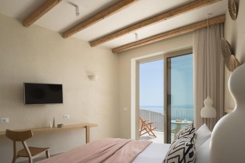 a bedroom with a bed and a view of the ocean at Stella in the Village Studios in Plakias