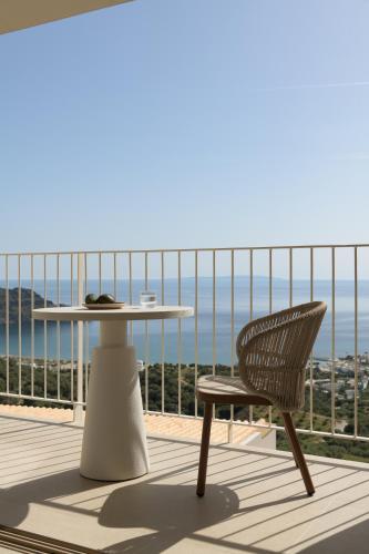 a table and a chair on a balcony with a view at Stella in the Village Studios in Plakias