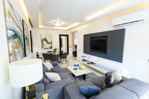 a living room with a couch and a tv at Bloom of Luxury in Limassol