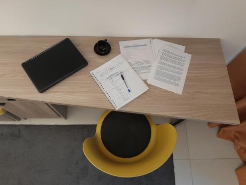 a wooden desk with a laptop and papers on it at Shade Suites & Studios in Beirut