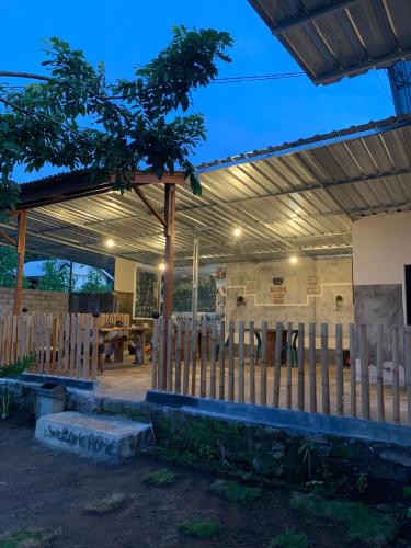 a pavilion with a wooden fence and a table at Iza home stay in Senaru