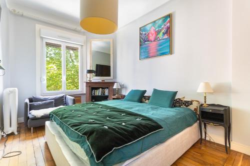 une chambre avec un grand lit et une chaise dans l'établissement Spacious 3 bedrooms apartement 135 m & privative parking, à Lille