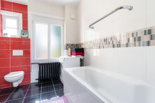 une salle de bain avec une baignoire blanche et des toilettes dans l'établissement Spacious 3 bedrooms apartement 135 m & privative parking, à Lille