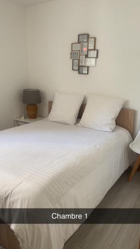 - une chambre dotée d'un lit avec des draps blancs dans l'établissement Villa OCEA, à La Ciotat