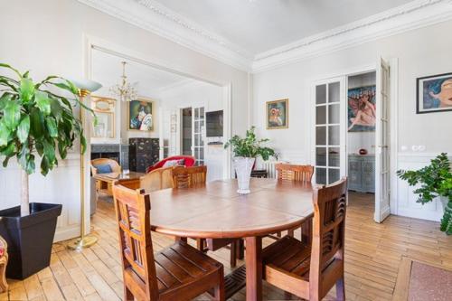 une salle à manger avec une table et des chaises en bois dans l'établissement Spacious 3 bedrooms apartement 135 m & privative parking, à Lille