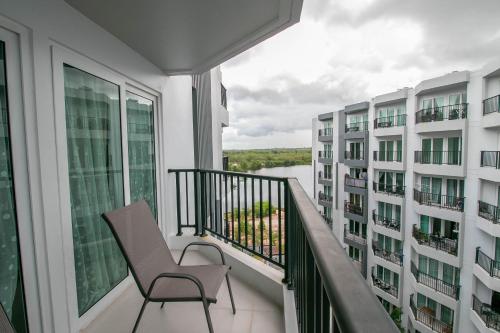 a balcony with a chair and two buildings at Mantra Beach Condominium Suite - Mae Phim in Ban Tha Fat