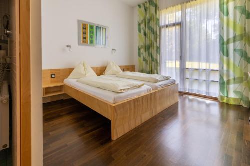 a bed in a room with a large window at Bildungshaus Schloss Retzhof in Wagna