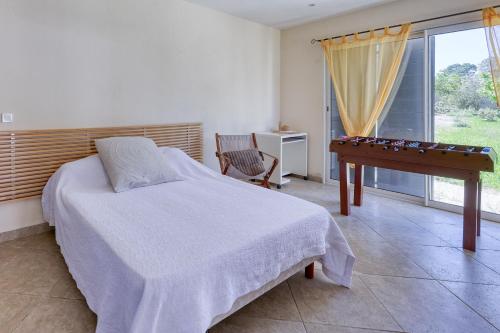 une chambre avec un lit, une table et une fenêtre dans l'établissement L'Hacienda - Villa Climatisée avec Piscine, à Lorgues