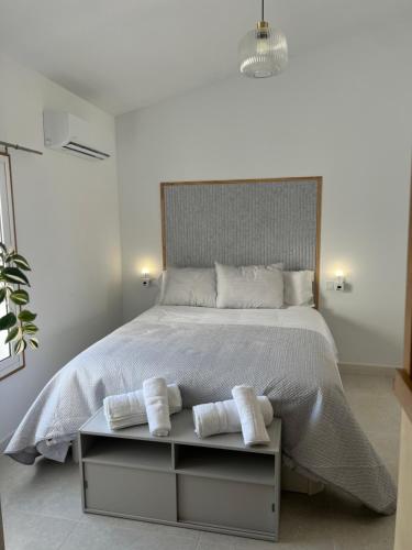 a white bedroom with a large bed with two towels at Casa Roberto in Alora