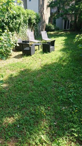 two benches sitting in the grass in a yard at HYPER CENTRE AVEC JARDIN 47m2 COSY in Boulogne-sur-Mer