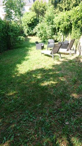 a group of benches sitting in the grass at HYPER CENTRE AVEC JARDIN 47m2 COSY in Boulogne-sur-Mer