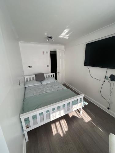 a bedroom with a bed and a flat screen tv at Studio Room in Great Parndon