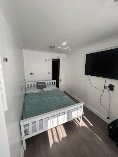 a bedroom with a bed and a flat screen tv at Studio Room in Great Parndon