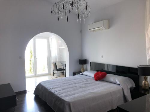 Un dormitorio con una cama grande y una lámpara de araña. en Villa Daria Kamares Tala Luxury Sea View, en Pafos
