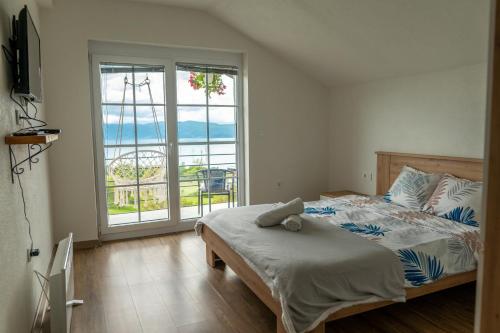 a bedroom with a bed and a large window at Villa Grkasha in Ohrid