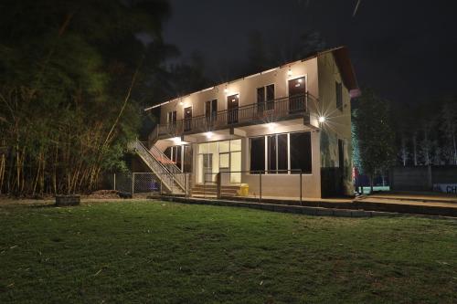 a house with lights on the side of it at night at Trippr Chikkamagaluru in Chikmagalūr