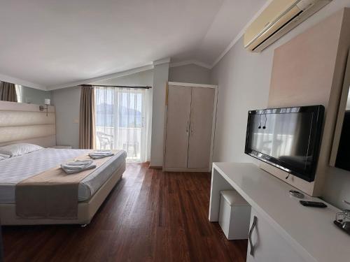 a bedroom with a bed and a flat screen tv at Gold Butik Otel in Marmaris