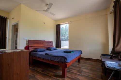 a bedroom with a bed and a window at Trippr Chikkamagaluru in Chikmagalūr
