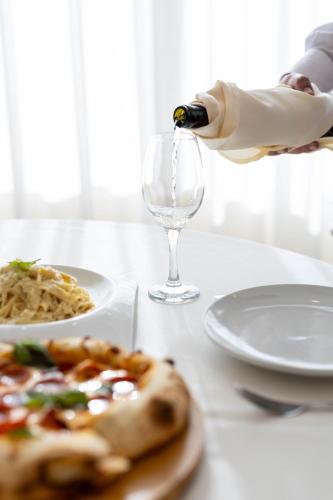 a person is pouring wine into a wine glass at Mateus Hotel & Pool in Jounieh
