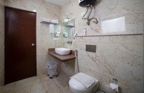 een badkamer met een toilet, een wastafel en een douche bij Sumitel Pelling in Pelling