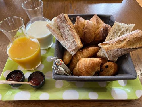 einen Teller Brot und Gebäck sowie ein Glas Orangensaft in der Unterkunft Au Chai Bigaroux Saint-Emilion in Saint-Sulpice-de-Faleyrens