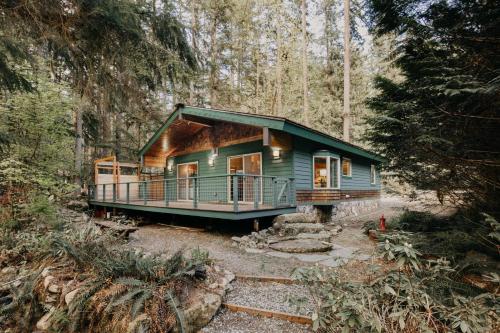 a house in the middle of a forest at Glacier Springs Cabin 60 - Soaker Tub - Blu-Ray - Sleeps 4 in Maple Falls