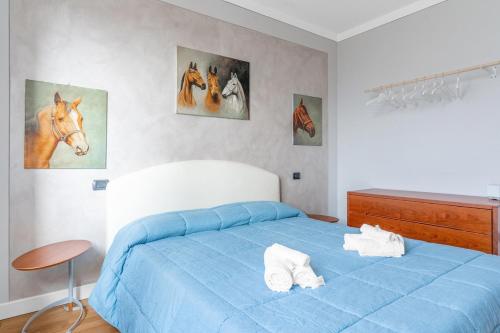 - une chambre avec un lit bleu et des peintures murales dans l'établissement Residenza degli Ulivi, Green House with Pool at Sassabanek, à Iseo