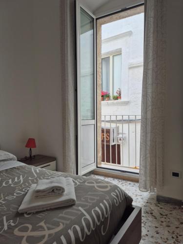 a bedroom with a bed and a window with a balcony at Casa Aurora in Polignano a Mare
