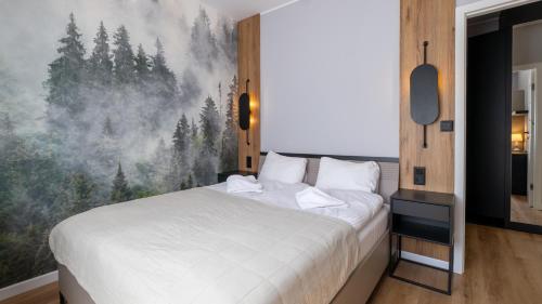 a bedroom with a bed and a painting of trees at River Park, Sun & Snow in Wisła