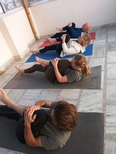 a group of people sitting on the floor doing yoga at Krishnabalram wellness & Ayurveda centre in Rishīkesh