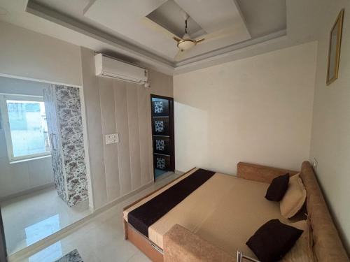 a bedroom with a bed and a couch and a window at Krishnabalram wellness & Ayurveda centre in Rishīkesh